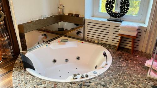 a large bath tub in a room with a window at Hotel Krone Sihlbrugg in Sihlbrugg Dorf