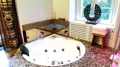 a large bath tub in a bathroom with a mirror at Hotel Krone Sihlbrugg in Sihlbrugg Dorf