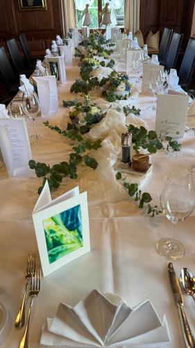 a long table with white table cloth with green flowers at Hotel Krone Sihlbrugg in Sihlbrugg Dorf