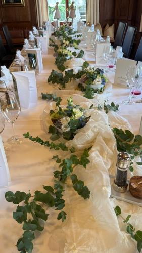 a long table with white tables with flowers on it at Hotel Krone Sihlbrugg in Sihlbrugg Dorf
