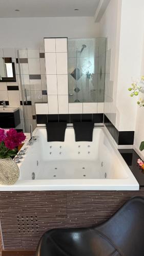 a large bath tub in a bathroom with flowers at Hotel Krone Sihlbrugg in Sihlbrugg Dorf