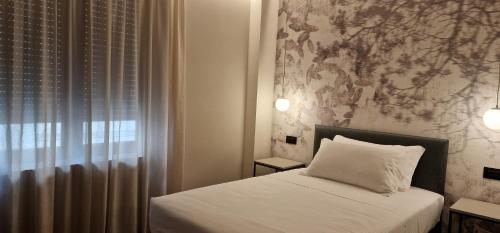 a small bedroom with a bed and a window at Hotel La Rocca in San Marino