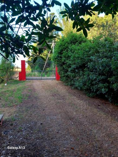 a red gate in the middle of a dirt road at Dimora Montenegro 