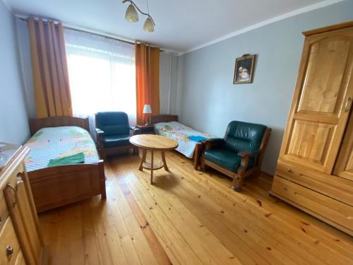 a bedroom with a bed and two chairs and a table at Agroturystyka Katarzyna Tarasiewicz in Stary Folwark