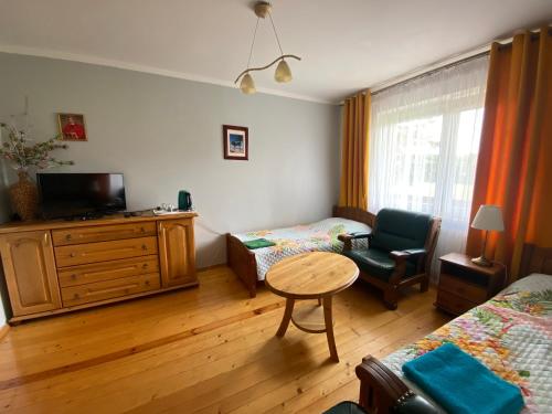 a living room with a bed and a table and a chair at Agroturystyka Katarzyna Tarasiewicz in Stary Folwark