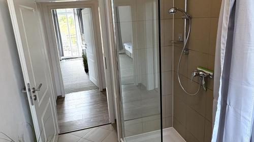 a bathroom with a shower with a glass door at Haus am Röblinsee - Ferienwohnungen in Fürstenberg in Fürstenberg-Havel
