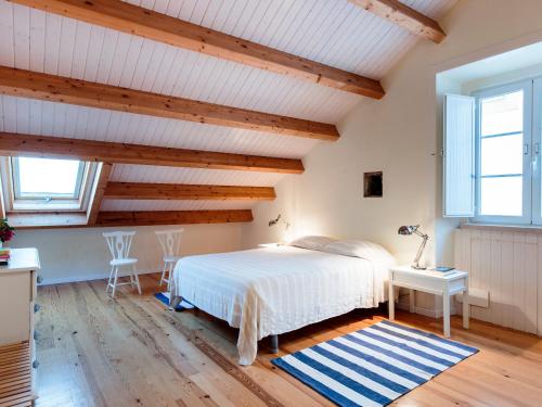 a bedroom with a bed and two windows at Casa Azul do Cais in São Martinho do Porto