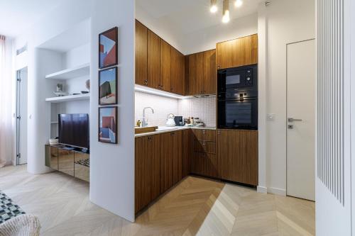 une cuisine avec des armoires en bois et un réfrigérateur dans l'établissement BERLIOZ - Splendid apartment in Nice city center, à Nice