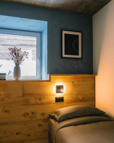 a bedroom with a bed and a window with a vase at Locanda del Viandante by Heima in Faido