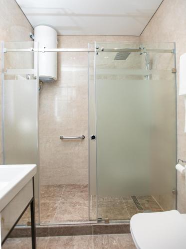 a shower with a glass door in a bathroom at Kaganat Boutique Hotel in Osh