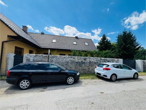 two cars parked in a driveway in front of a house at Apartmán Zara in Dobrá Voda