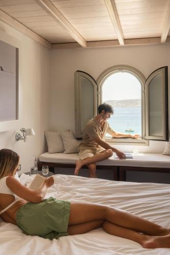 a man and a woman laying on a bed in a room at Grace Mykonos in Agios Stefanos