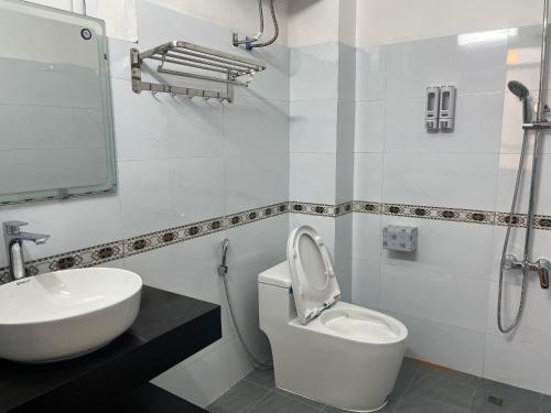Un baño con un inodoro blanco y un lavabo. en Khách Sạn Gia Hưng, en Ninh Binh