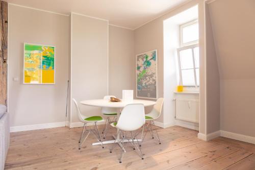 a dining room with a white table and chairs at OSTKÜSTE - Villa Albatros Design Apartments in Ahlbeck