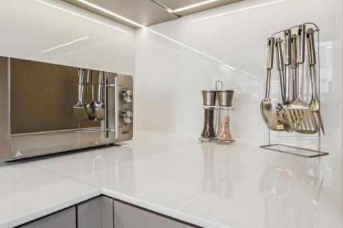 a kitchen with silver utensils hanging on a wall at UP&GREAT Apartments - Chic Urban Homes in Zürich