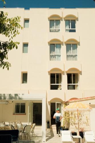 a man standing in front of a building at Hôtel Le Sud in Juan-les-Pins