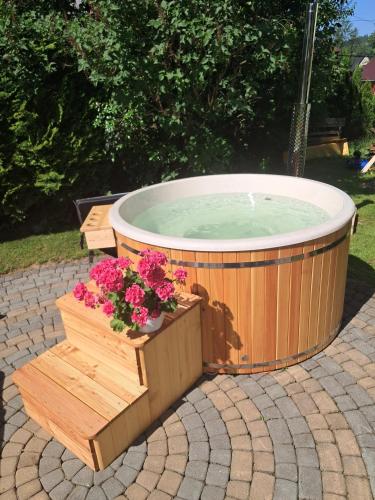 a large hot tub with flowers in a wooden crate at Kwatery Maciata in Biały Dunajec