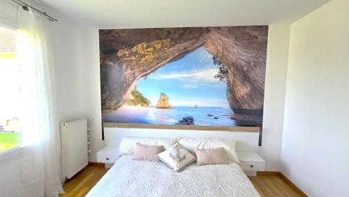 une chambre avec un grand tableau sur le mur dans l'établissement Villa DES COEURS NORMANDS, à Pirou