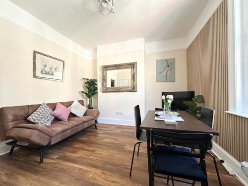 a living room with a couch and a table at The Bournemouth Hideaway - Beautiful Central flat - 10 mins walk to beach - Brought to you by Coastline Retreats in Bournemouth