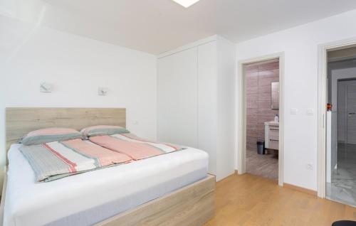 a white bedroom with a bed and a bathroom at Villa Nada sea view&whirpool island Krk by Villas in Omišalj