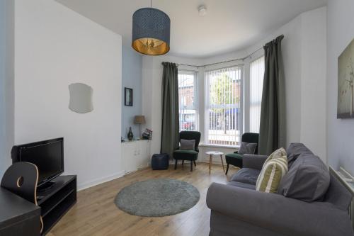 a living room with a couch and a tv at Albert Lodge in Belfast