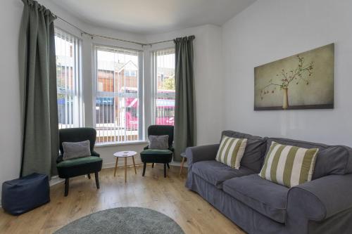 a living room with a couch and chairs and a window at Albert Lodge in Belfast