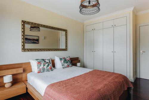 a bedroom with a bed and a mirror at Spacious 1BR with Parking in Quiet Area in Vila Nova de Gaia