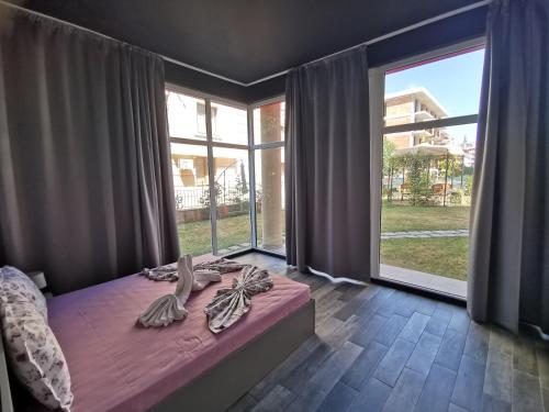 En eller flere senge i et værelse på Rose Garden Omax Apartments