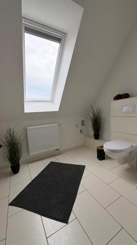 a bathroom with a toilet and a window at Haus am Röblinsee - Ferienwohnungen in Fürstenberg in Fürstenberg-Havel