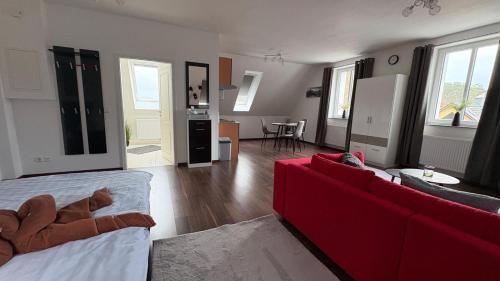 a living room with a red couch and a red sofa at Haus am Röblinsee - Ferienwohnungen in Fürstenberg in Fürstenberg-Havel
