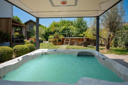 - un bain à remous extérieur dans la cour avec un parasol dans l'établissement La suite des Sommets, à Barberaz