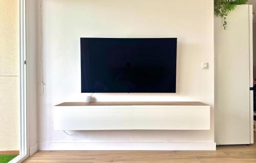 a living room with a tv on a white wall at 2 Bedroom Gorgeous Apartment In Sagunto in Sagunto