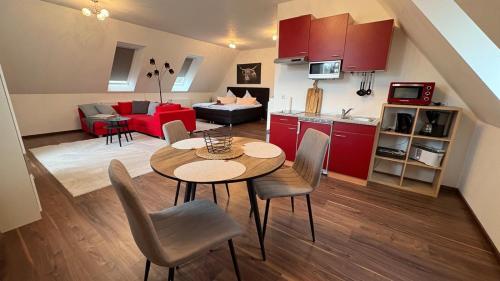 a kitchen and a living room with a table and chairs at Haus am Röblinsee - Ferienwohnungen in Fürstenberg in Fürstenberg-Havel