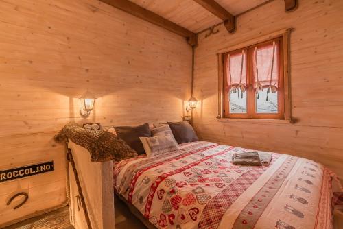 a bedroom with a bed in a log cabin at Il Roccolino in Valsecca