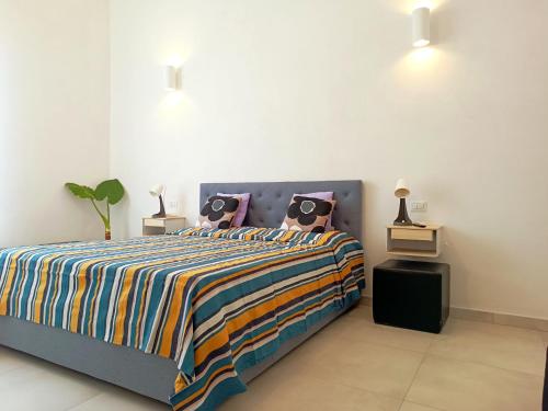 a bedroom with a bed with a colorful comforter and pillows at Alghero Vacanza in Alghero