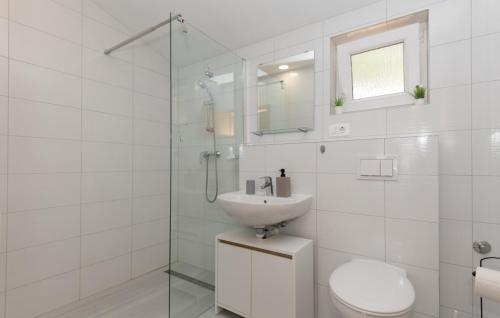 een witte badkamer met een wastafel en een douche bij Villa Primabella -Makarska by Villas Guide in Novak