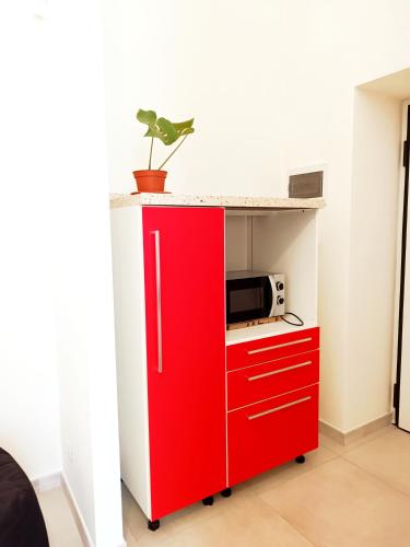 a red cabinet with a microwave on top of it at Alghero Vacanza in Alghero