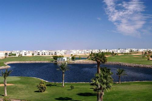 a view of a resort with a pond and palm trees at Pickalbatros Golf Luxury Suites - All Inclusive in Sharm El Sheikh