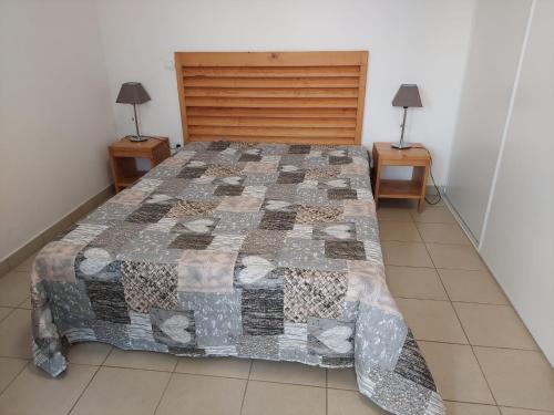 une chambre avec un lit avec une couette dessus dans l'établissement T3 résidence privée proche plage et piscine, à Poggio-Mezzana