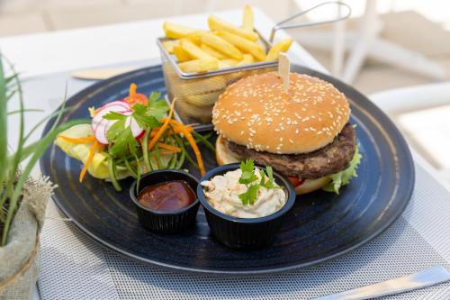 a plate of food with a hamburger and french fries at Venus Beach Hotel in Paphos City