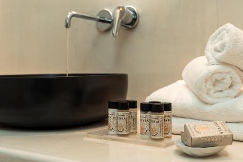 a bathroom with towels and a sink and two bottles at Oikos Santorini Living Concept in Fira