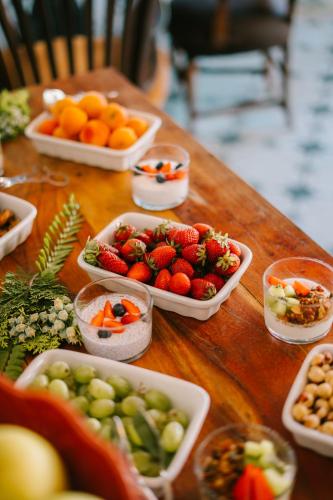 a wooden table topped with bowls of fruit and vegetables at Hotel Son Molí Country House in Playa de Palma