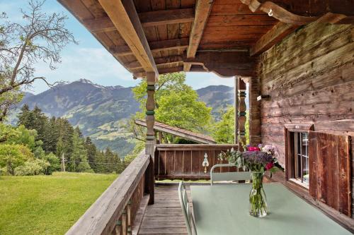 a porch of a log cabin with a vase of flowers at Berghof Moosen in Hart im Zillertal