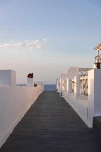 a walkway leading to the ocean on a white building at Vrachia Studios & Apartments in Oia