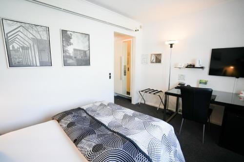 a bedroom with a bed and a desk with a computer at Golf Hotel Viborg in Viborg