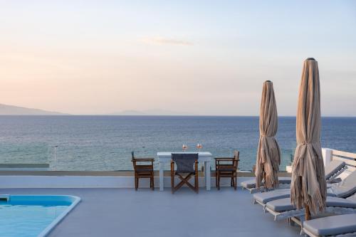 a patio with a table and chairs and the ocean at Vrachia Studios & Apartments in Oia