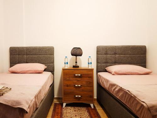a bedroom with two beds and a dresser with a lamp at #481 - Spacious 3BR Duplex with Private Garden in Datca