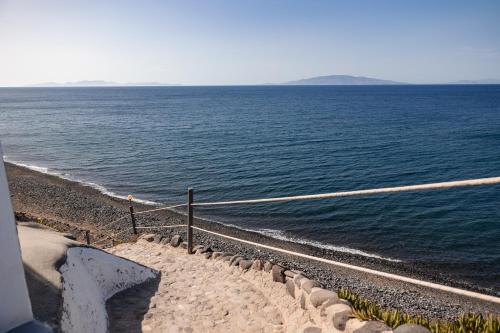 a view of the ocean with a stone path next to it at Vrachia Studios & Apartments in Oia