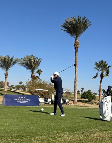 a man swinging a golf club on a golf course at Pickalbatros Golf Luxury Suites - All Inclusive in Sharm El Sheikh