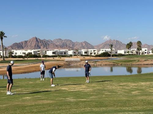 a group of people playing golf on a golf course at Pickalbatros Golf Luxury Suites - All Inclusive in Sharm El Sheikh
